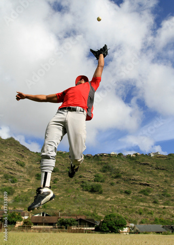 Photo: Baseball player jumps high to catch a fly ball Baseball player jumps high to catch a fly ball