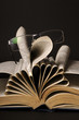 glasses on pages of book isolated on black