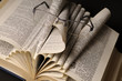 glasses on pages of book isolated on black