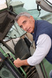 portrait of a farmer climbing on tractor