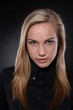 Unsmiling, blonde teenager in black