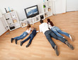 Foto: Young family watching TV at home Young family watching TV at home