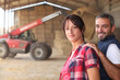 Agricultural couple in the barn with a tractor