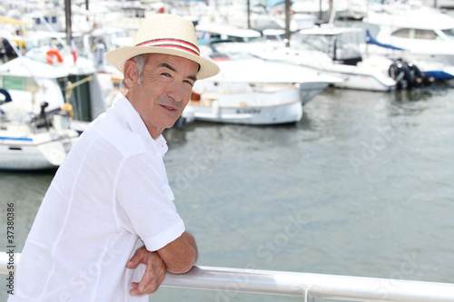 Photo: Older man in a straw panama hat standing by a marina Older man in a straw panama hat standing by a marina