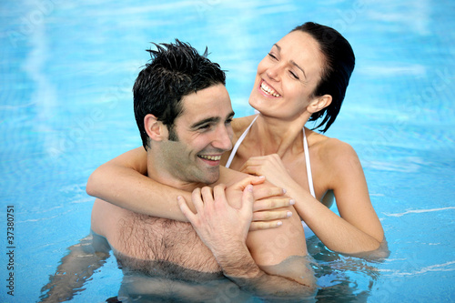 Photo: Couple hugging in swimming pool Couple hugging in swimming pool