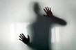 Shadowy figure behind glass