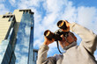 Little boy with binoculars outdoor; modern skyscrapers