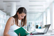 pretty female college student studying in the university library