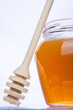 Jar of honey with wooden drizzler
