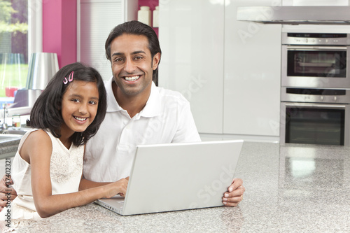 Photo: Asian Indian Father & Daughter Using Laptop Computer at Home Asian Indian Father & Daughter Using Laptop Computer at Home