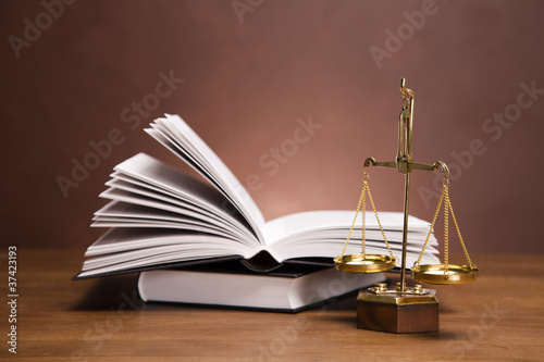 Photo: Scales of justice and gavel on desk with dark background Scales of justice and gavel on desk with dark background