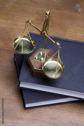 Photo: Scales of justice and gavel on desk with dark background Scales of justice and gavel on desk with dark background