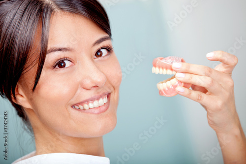 Photo: Woman holding teeth sample Woman holding teeth sample