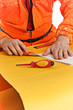 worker cuts the folded sheet of paper worker cuts the folded sheet of paper