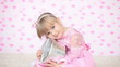 Girl holding a gift sitting on the carpet