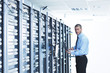 businessman with laptop in network server room
