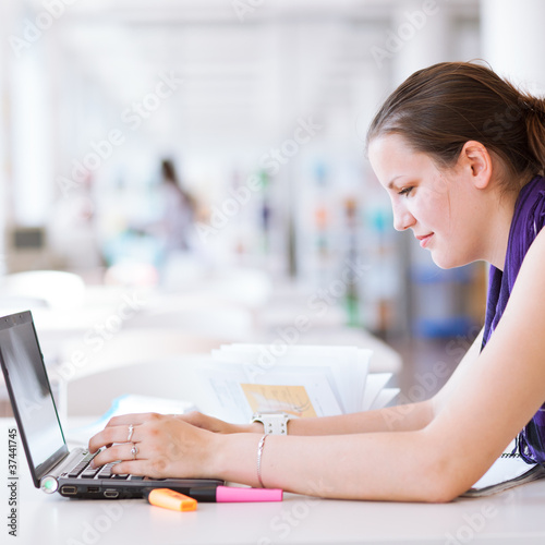 Photo: pretty female college student studying in the university library pretty female college student studying in the university library
