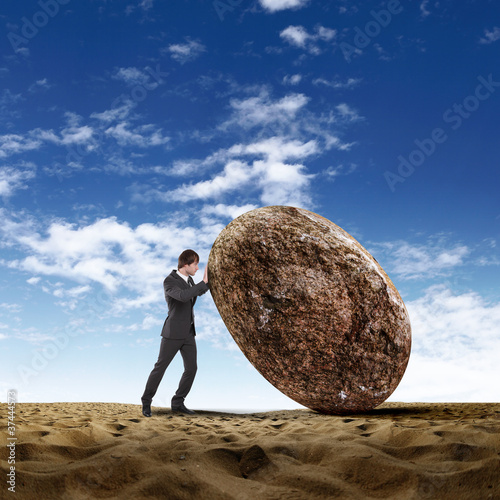 Illustration: Businessman rolling a giant stone Businessman rolling a giant stone