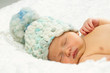 Newborn Baby Sleeping with knitted Hat on.