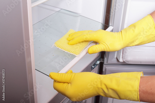 Photo: Hands cleaning refrigerator. Hands cleaning refrigerator.