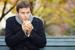 Mann trinkt Tee im Herbst