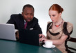 Business colleagues at office desk with two laptops