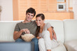 Foto: Couple with popcorn on the sofa watching a movie Couple with popcorn on the sofa watching a movie