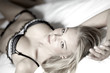 junge blonde frau liegt im bett