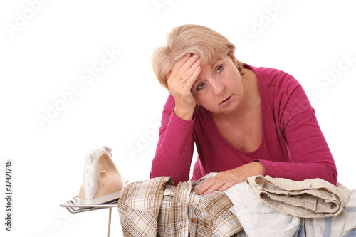 Photo: Erschöpfte Hausfrau am Bügeltisch.. Erschöpfte Hausfrau am Bügeltisch..