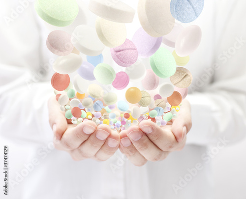 Photo: Colorful pills falling into open palms Colorful pills falling into open palms