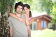 Young couple embraced against a tree