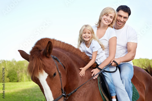 Photo: Attractive family on a brown horse Attractive family on a brown horse