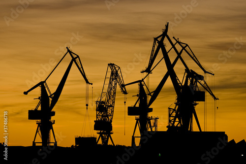 Foto: Orange sunset and shipyard cranes Orange sunset and shipyard cranes