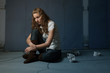 Sad lone girl sitting on flor in darkness