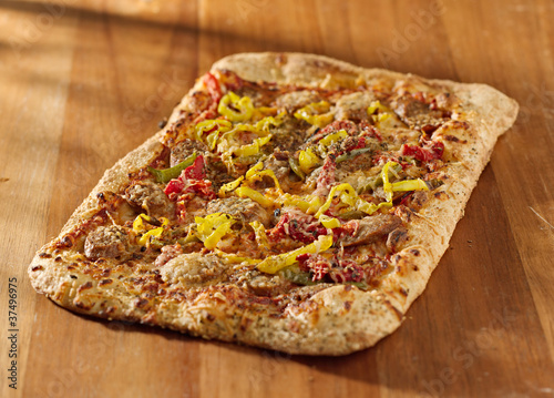 Photo: gourmet pizza with sausage and colorful peppers gourmet pizza with sausage and colorful peppers