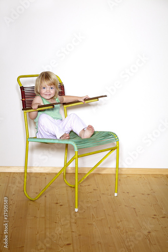 Photo: mädchen sitzt auf sessel mädchen sitzt auf sessel