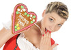 Blonde junge Frau im Dirndl mit Lebkuchenherz
