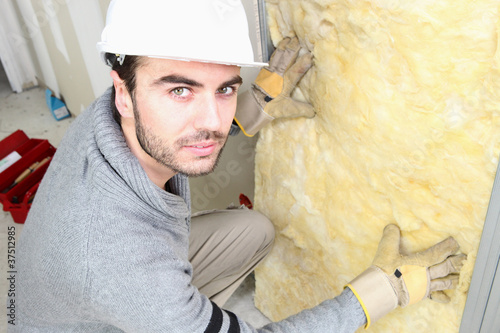 Photo: Man making sure house is well insulated Man making sure house is well insulated