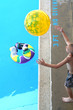Boy Catching Beach Ball at Pool