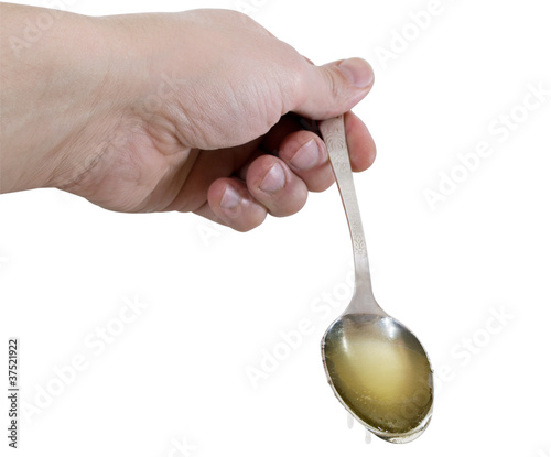 Photo: hand with spoon of honey hand with spoon of honey