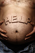 Man's stomach with a sticking out inscription help
