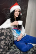 Young caucasian woman with cup of tea in santa hat Young caucasian woman with cup of tea in santa hat
