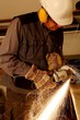 Arbeiter mit Trennschleifer und Helm