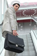 executive climbing escalator