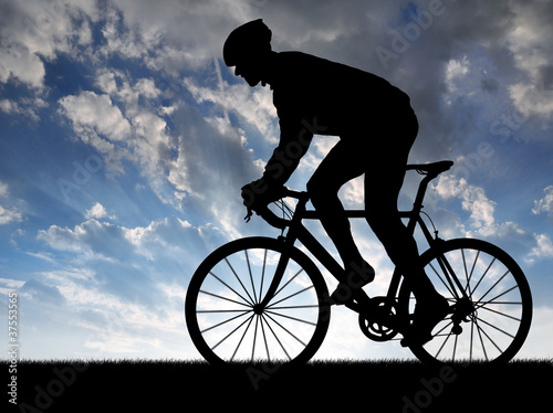 Photo: silhouette of the cyclist riding a road bike at sunset silhouette of the cyclist riding a road bike at sunset