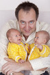 happy father with his  identical baby twin daughters