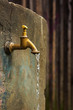 Old rusty water tap on cracked concrete wall