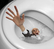 Businessman sinking in toilet bowl