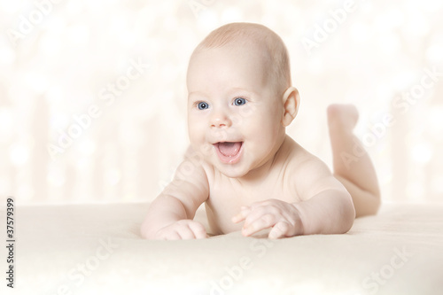 Photo: Happy active baby lying on stomach over blanket Happy active baby lying on stomach over blanket