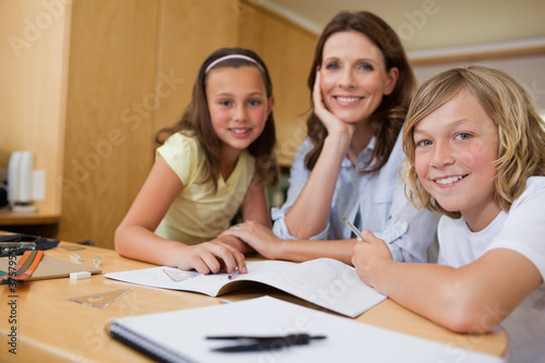 Photo: Mother doing homework with children Mother doing homework with children
